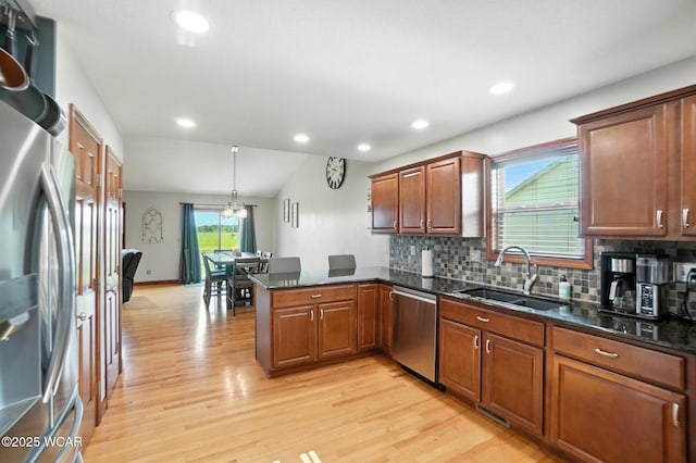 13286 Arrowhead Dr, Findlay, OH 45840 - kitchen featuring stainless steel appliances, a peninsula, light wood-type flooring, backsplash, and brown cabinetry