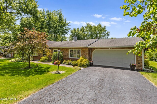 3540 Yoakam Rd, Lima, OH 45806 - single story home featuring a front yard, an attached garage, driveway, a chimney, and stone siding