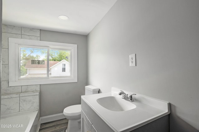 526 S Pine St, Lima, OH 45804 - bathroom with a tub to relax in, toilet, vanity, wood finished floors, and baseboards