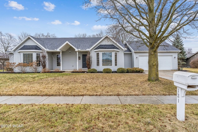 single story home featuring driveway, a front lawn, and an attached garage