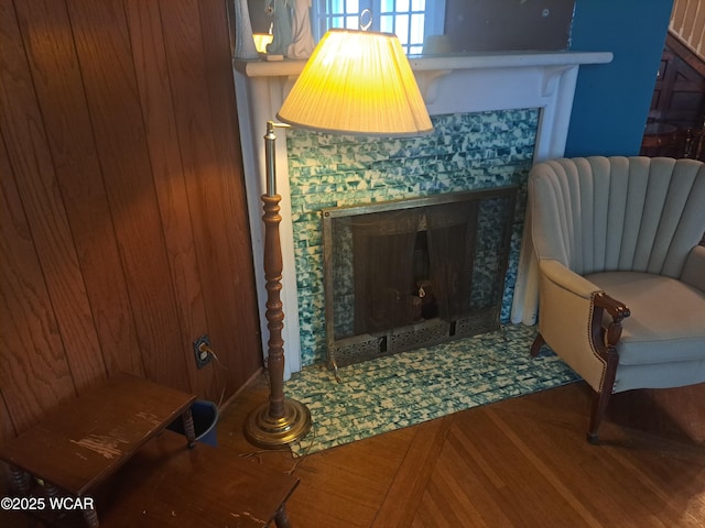 living area featuring wood-type flooring and a tile fireplace