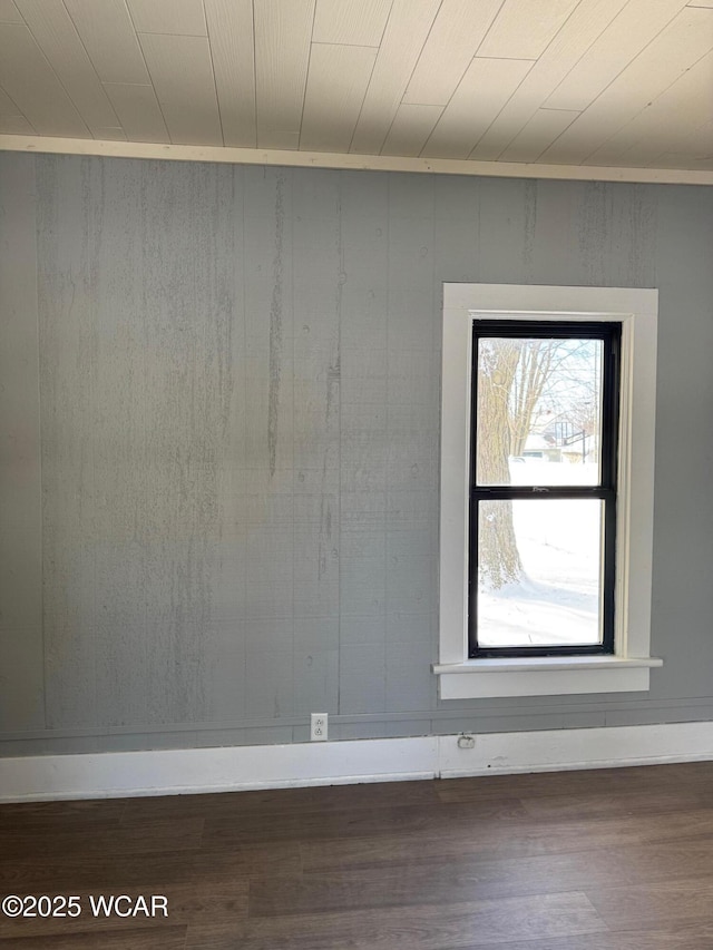 empty room with dark hardwood / wood-style floors and wood ceiling