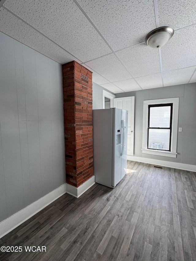 spare room with hardwood / wood-style flooring and a drop ceiling