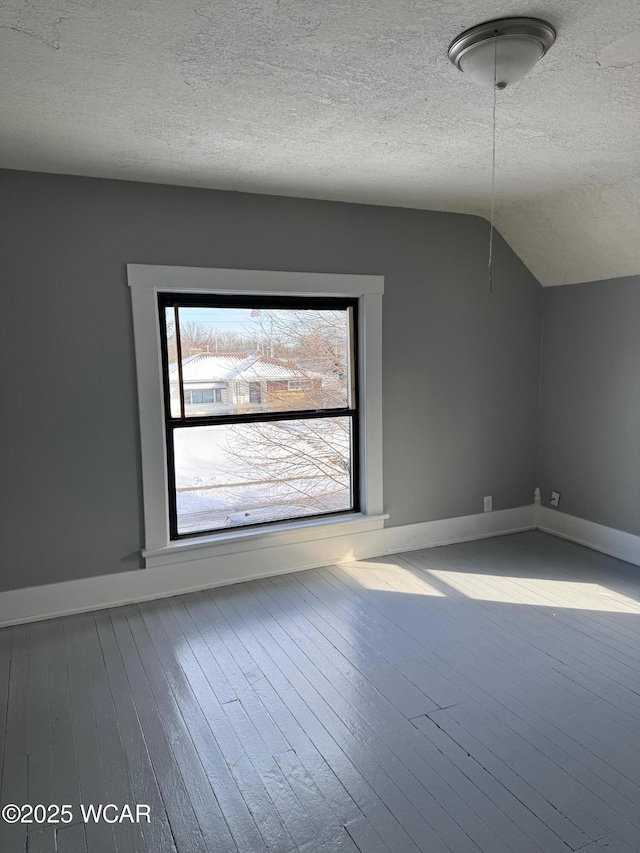 bonus room with hardwood / wood-style flooring, vaulted ceiling, and a textured ceiling