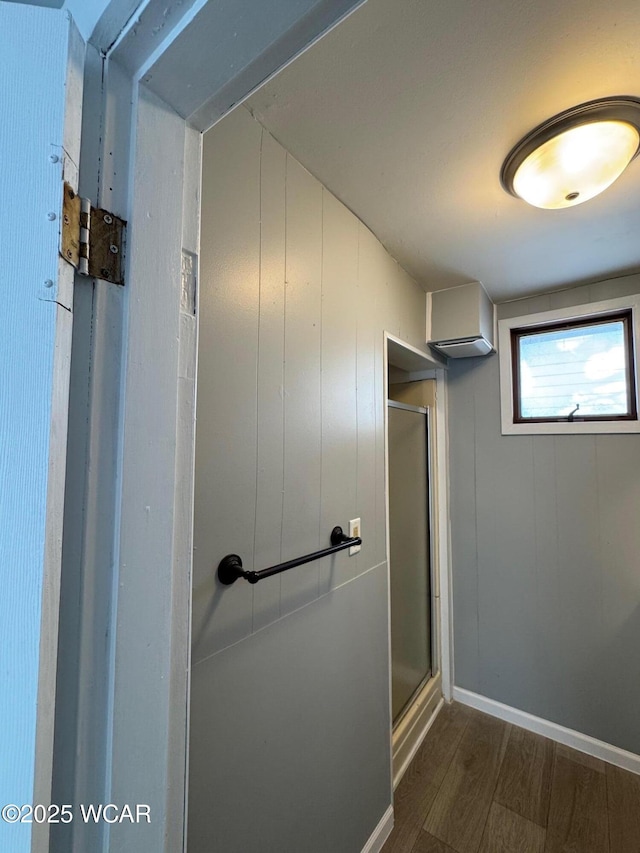 bathroom with an enclosed shower and hardwood / wood-style floors