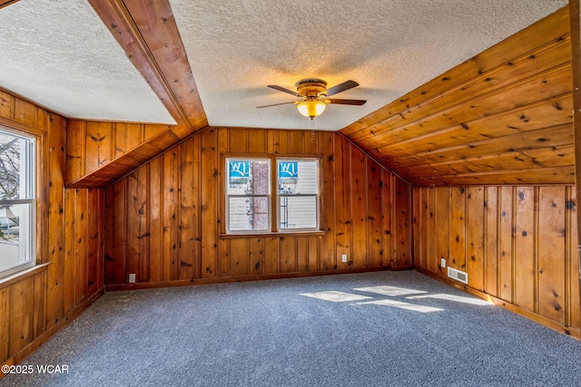 additional living space featuring plenty of natural light, carpet floors, and vaulted ceiling