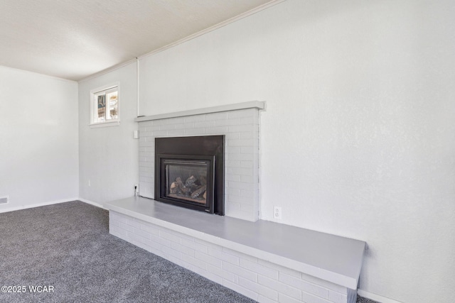 unfurnished living room with visible vents, carpet floors, a brick fireplace, and crown molding