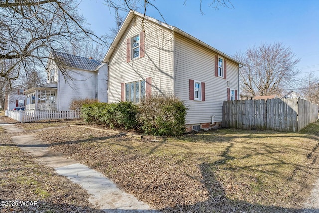 view of home's exterior featuring fence and a lawn