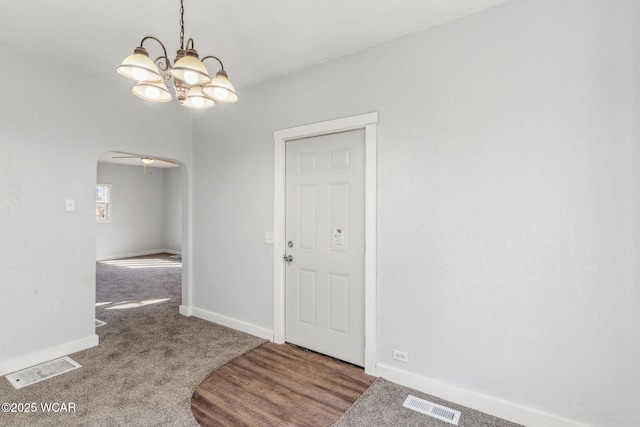 entrance foyer featuring visible vents, arched walkways, baseboards, and carpet flooring