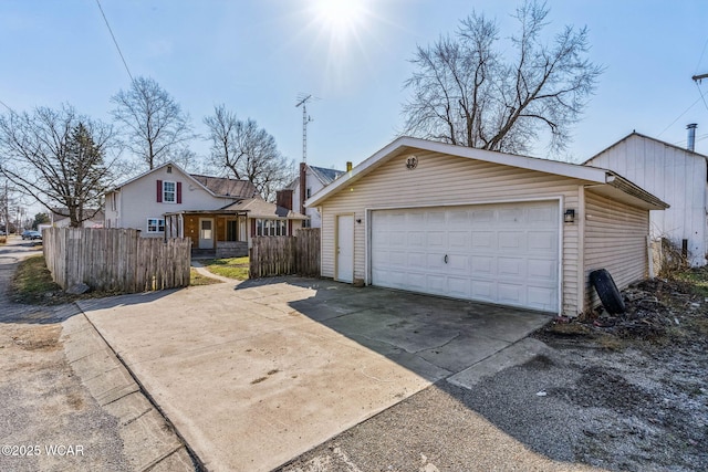 exterior space featuring an outbuilding, a garage, and fence