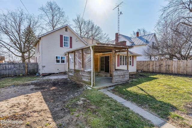 back of property featuring a yard, a patio, and a fenced backyard