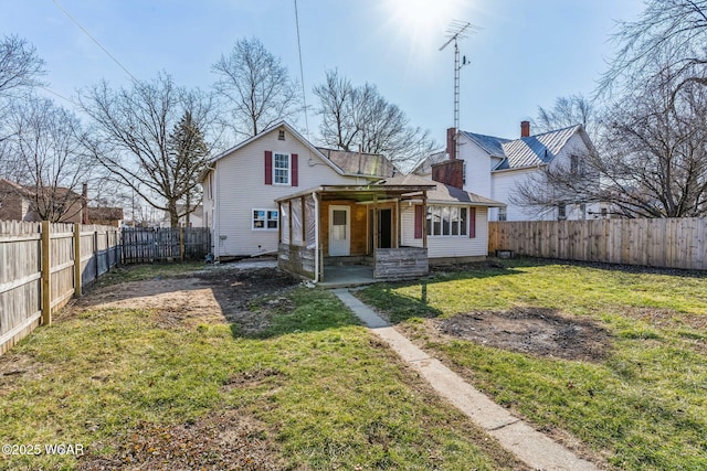 back of house featuring a lawn and a fenced backyard