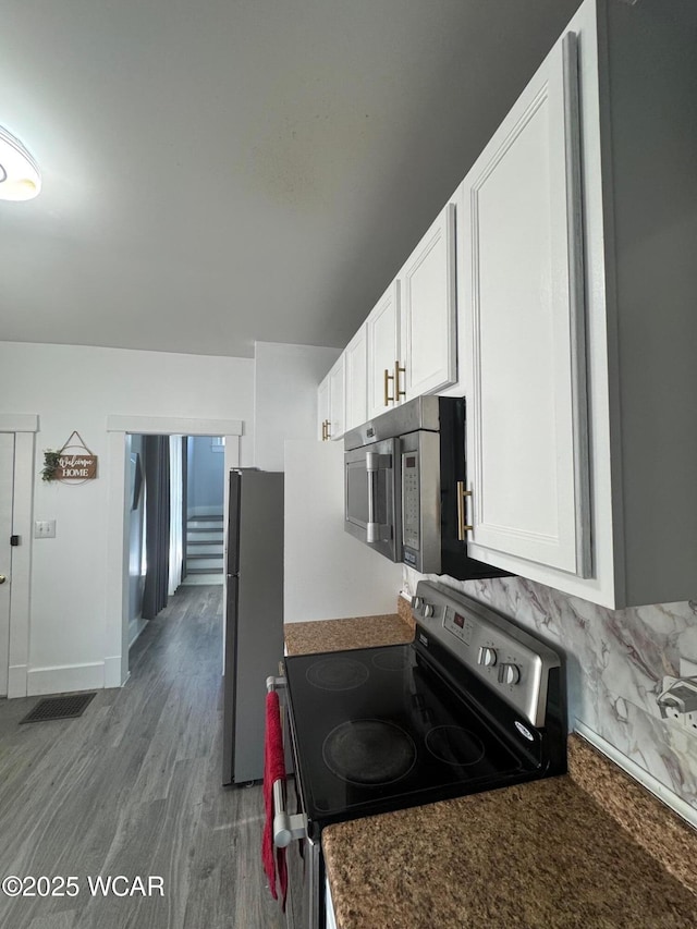 110 Heisel St, Kenton, OH 43326 - kitchen with appliances with stainless steel finishes, white cabinetry, wood finished floors, and dark countertops