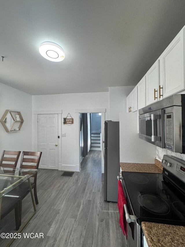 110 Heisel St, Kenton, OH 43326 - kitchen with appliances with stainless steel finishes, wood finished floors, and white cabinetry