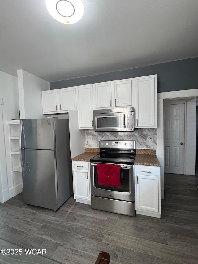 110 Heisel St, Kenton, OH 43326 - kitchen with appliances with stainless steel finishes, dark countertops, white cabinetry, dark wood-style floors, and tasteful backsplash