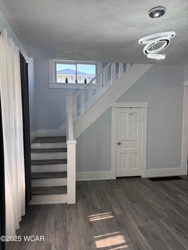 110 Heisel St, Kenton, OH 43326 - stairway with a textured ceiling, wood finished floors, and a chandelier