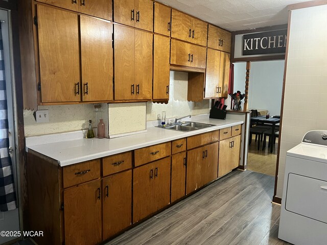 314 N Market St, Kenton, OH 43326 - kitchen featuring washer / dryer, wood finished floors, light countertops, and brown cabinets