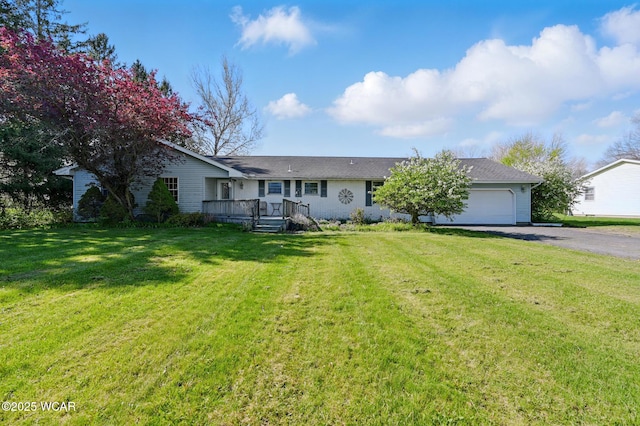 single story home featuring driveway, a front yard, and a garage