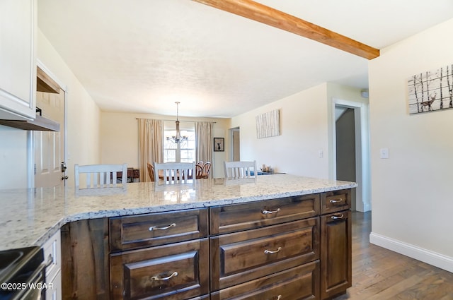 kitchen featuring beamed ceiling, dark hardwood / wood-style flooring, a kitchen bar, hanging light fixtures, and dark brown cabinets