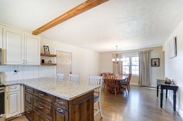 kitchen with dark wood-type flooring, backsplash, dark brown cabinetry, a kitchen bar, and decorative light fixtures