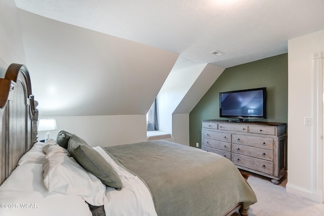 bedroom featuring vaulted ceiling and light carpet