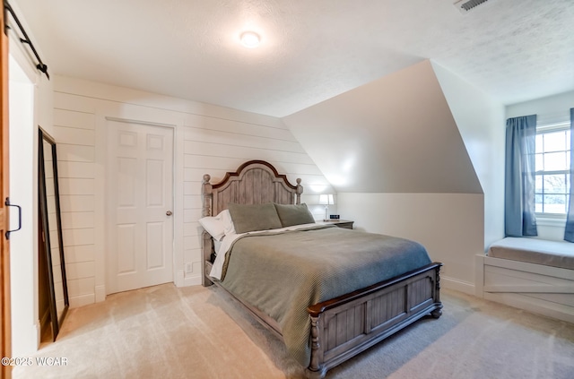 carpeted bedroom with lofted ceiling and a textured ceiling