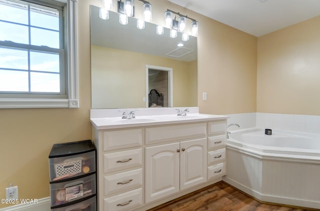 bathroom featuring vanity, wood-type flooring, and a tub