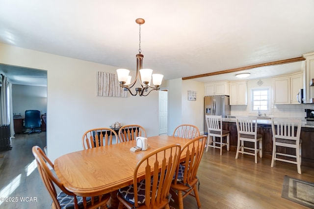 dining space featuring sink, dark hardwood / wood-style floors, and a chandelier