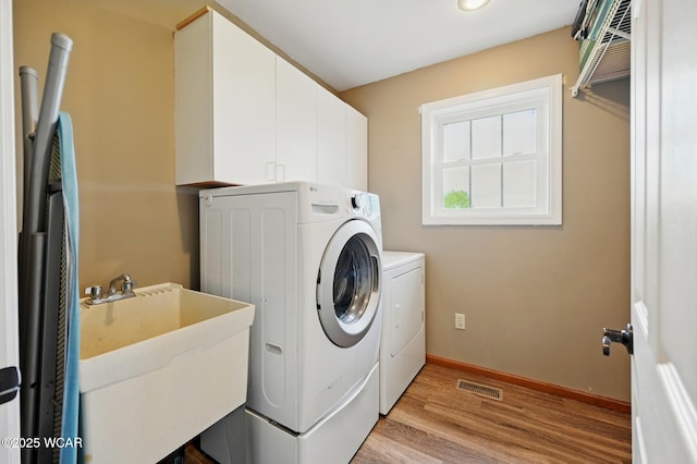 1106 S Grubb Rd, Lima, OH 45806 - laundry room with separate washer and dryer, light wood-style flooring, cabinet space, and baseboards