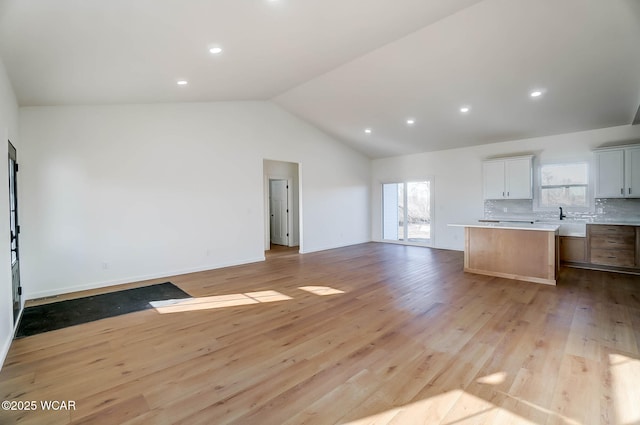 1771 Baty Rd, Lima, OH 45807 - unfurnished living room with light wood-type flooring, lofted ceiling, a sink, recessed lighting, and baseboards