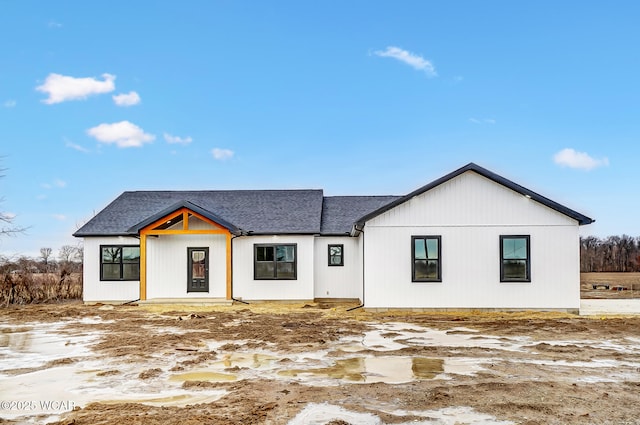 modern inspired farmhouse with a shingled roof