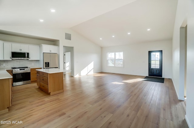 1771 Baty Rd, Lima, OH 45807 - kitchen with appliances with stainless steel finishes, open floor plan, light wood-style flooring, a kitchen island, and light countertops