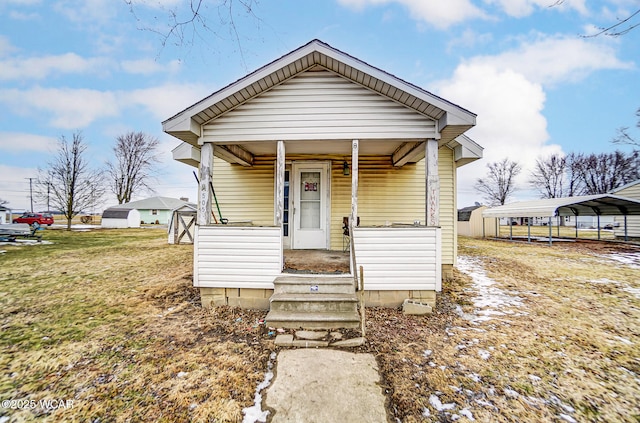 view of front of home featuring a porch, a front lawn, and a carport