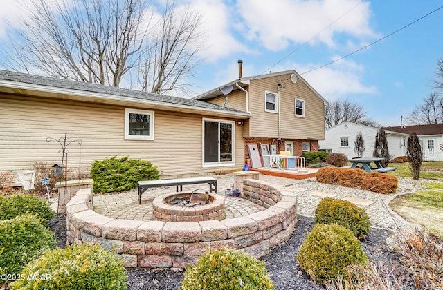 back of property with a patio, a wooden deck, and an outdoor fire pit