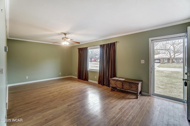 interior space featuring crown molding, baseboards, and wood finished floors