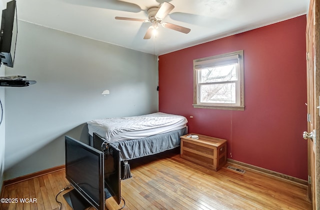 bedroom with hardwood / wood-style flooring, baseboards, visible vents, and ceiling fan