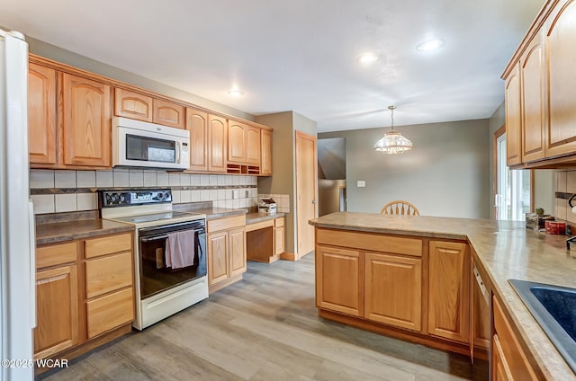 kitchen with white microwave, light wood finished floors, a peninsula, range with electric stovetop, and tasteful backsplash