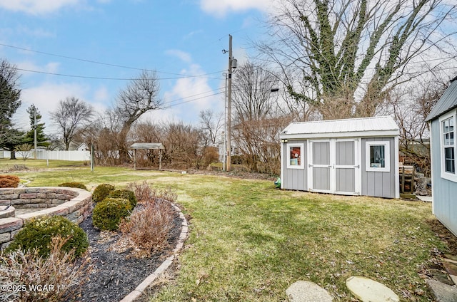 view of yard with fence, an outdoor structure, and a shed