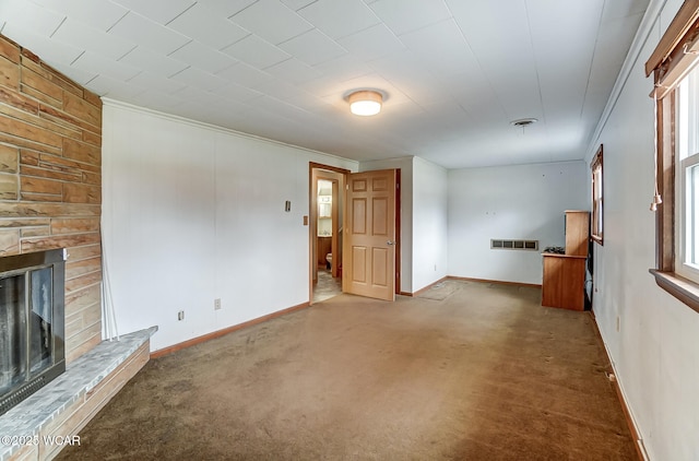 unfurnished living room featuring visible vents, crown molding, baseboards, carpet, and a fireplace