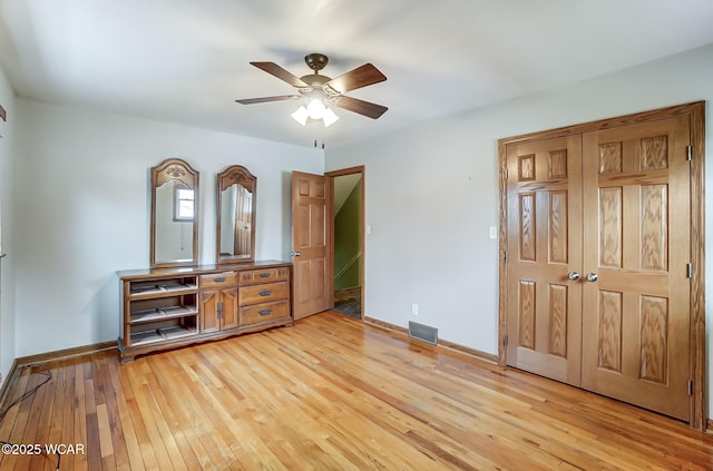 bedroom featuring visible vents, light wood-style flooring, a closet, baseboards, and ceiling fan