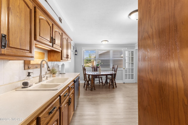 2435 Bible Rd, Lima, OH 45801 - kitchen with light wood-type flooring, dishwasher, light countertops, crown molding, and brown cabinets