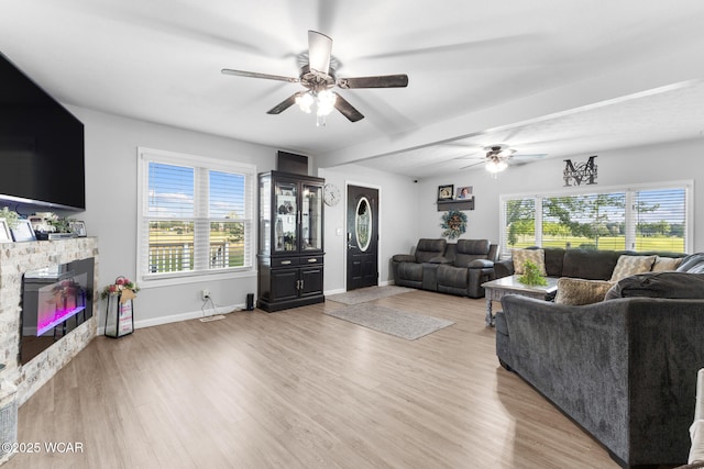 2435 Bible Rd, Lima, OH 45801 - living room with a ceiling fan, light wood-style flooring, a fireplace, and healthy amount of natural light