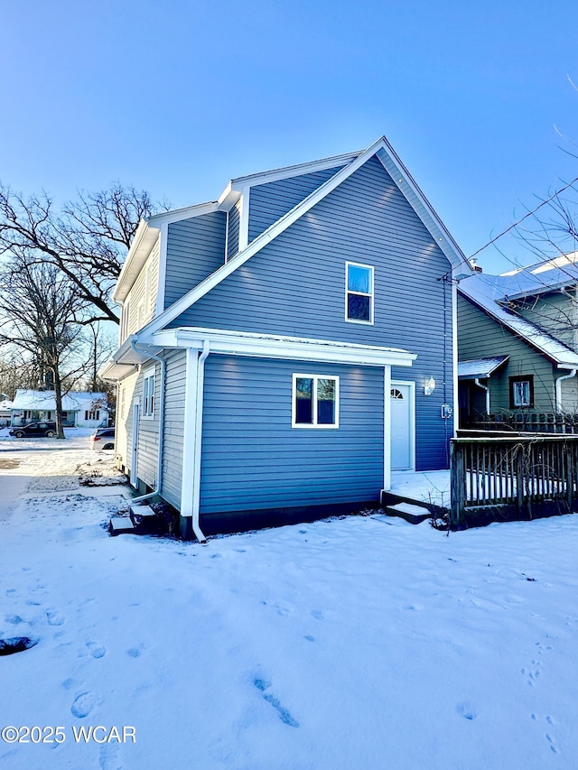 view of snow covered back of property