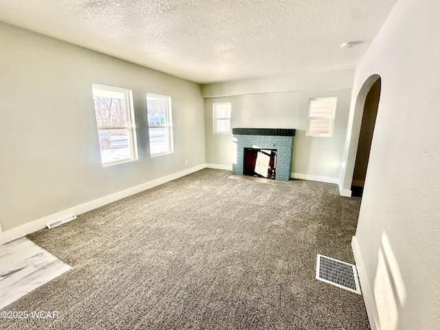 unfurnished living room with a textured ceiling and a fireplace