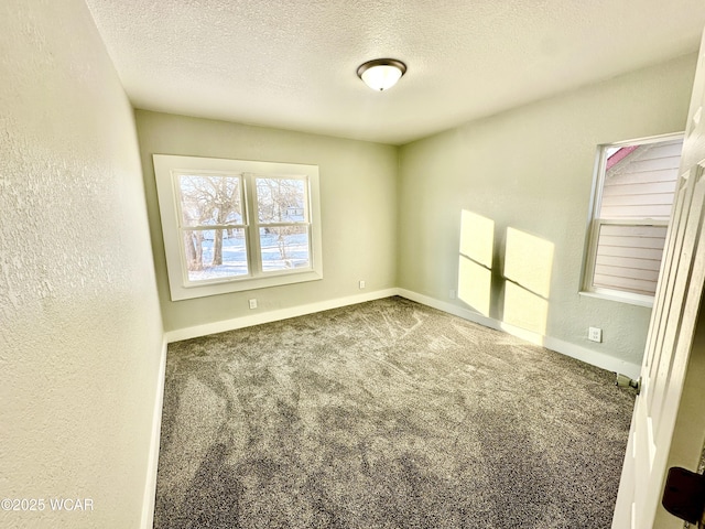 carpeted empty room with a textured ceiling