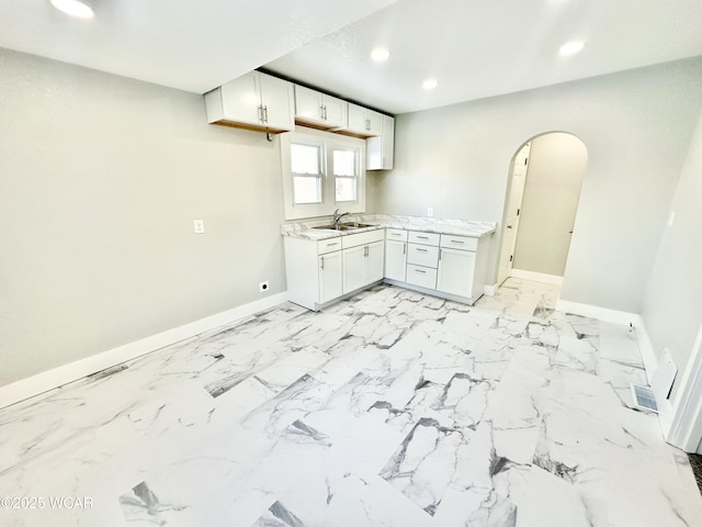 kitchen featuring white cabinetry and sink