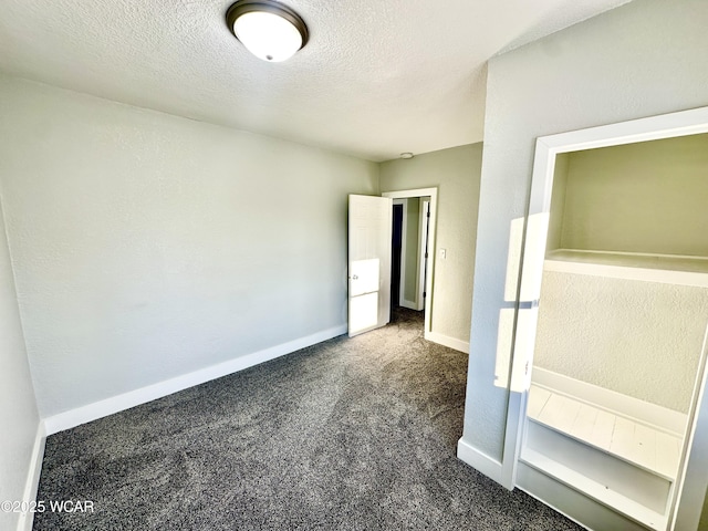 unfurnished bedroom featuring dark carpet and a textured ceiling