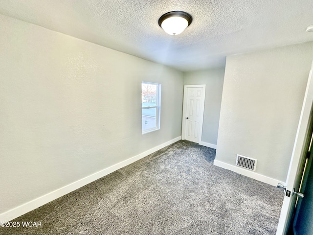 carpeted spare room featuring a textured ceiling