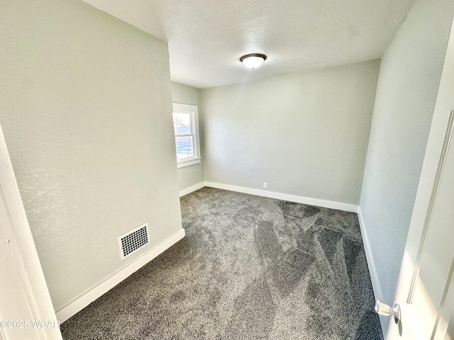 carpeted spare room featuring a textured ceiling