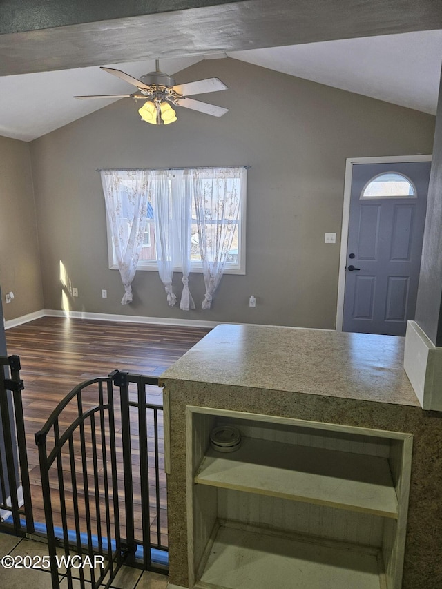 kitchen with open shelves, a ceiling fan, vaulted ceiling, wood finished floors, and baseboards